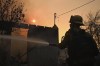 A firefighters waters down a home after the Eaton Fire burns in Altadena, Calif., Thursday, Jan. 9, 2025. (AP Photo/Nic Coury)