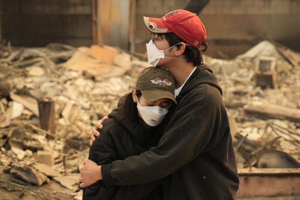 Ari Rivera, right, and Anderson Hao hold each other in front of their destroyed home in Altadena, Calif., Thursday, Jan. 9, 2025. (AP Photo/John Locher)