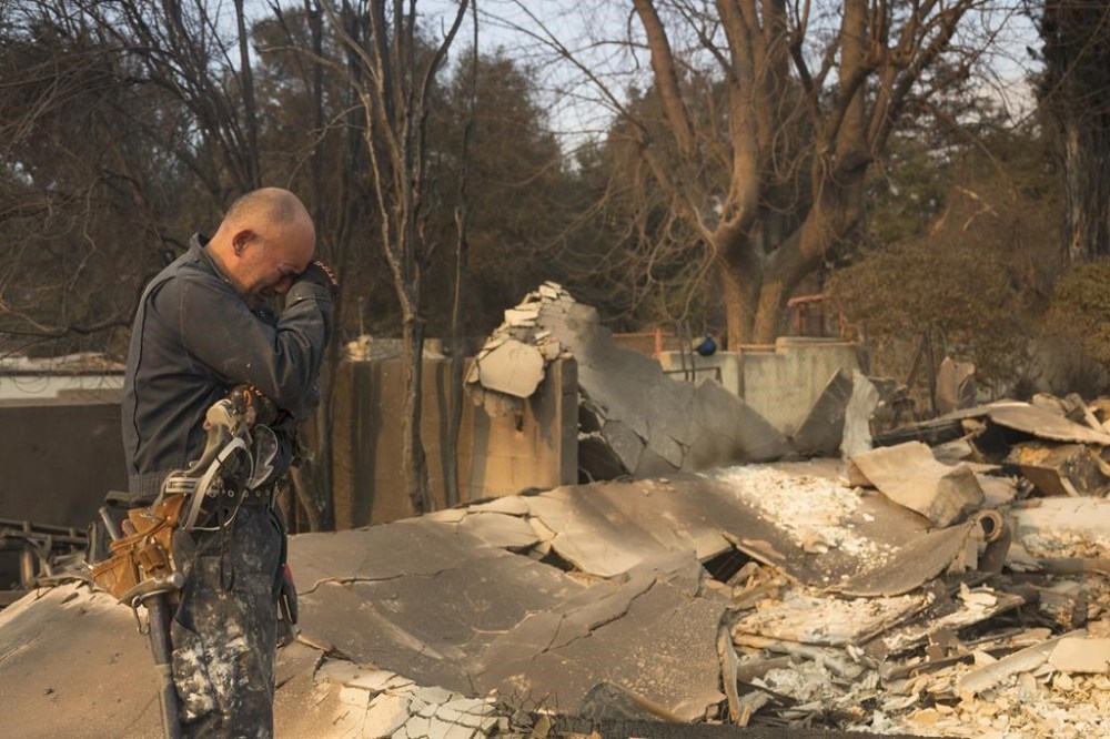 Cesar Plaza becomes emotional while looking at his home destroyed by the Eaton Fire in Altadena, Calif., Thursday, Jan. 9, 2025. (AP Photo/Nic Coury)
