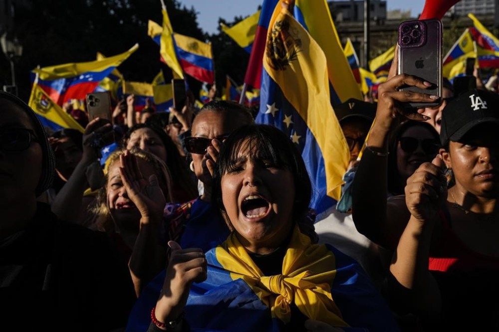 Opponents of Venezuelan President Nicolas Maduro participate in a protest the day before his inauguration for a third term, in Santiago, Chile, Thursday, Jan. 9, 2025. (AP Photo/Esteban Felix)