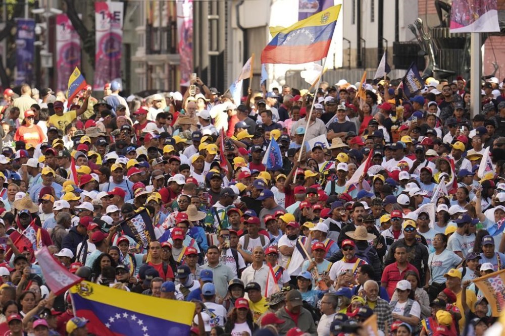 Government supporters listen to Venezuelan President Nicolas Maduro speak at Miraflores presidential palace in Caracas, Venezuela, on his inauguration day for a third term, Jan. 10, 2025. (AP Photo/Matias Delacroix)