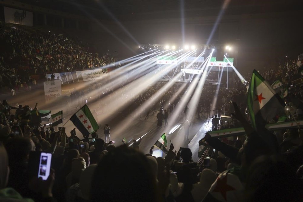 Syrians wave post-Assad flags during a concert by the recently returned