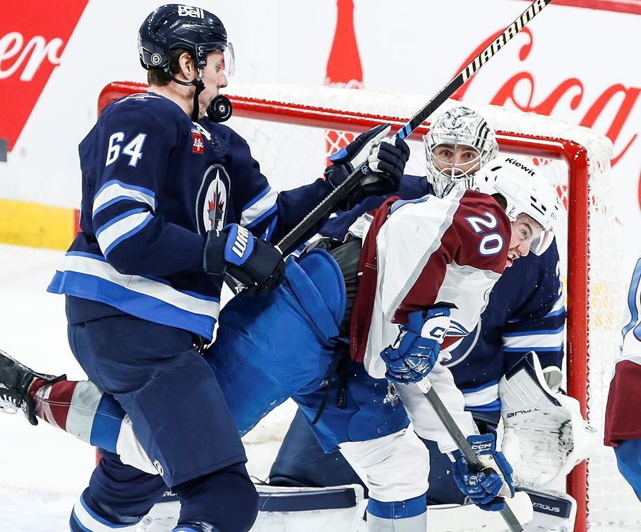 Winnipeg Jets' Logan Stanley (64) takes a puck to the face as he defends against Colorado Avalanche's Ross Colton (20) during first period NHL action in Winnipeg on Saturday, Jan. 11, 2025. THE CANADIAN PRESS/John Woods