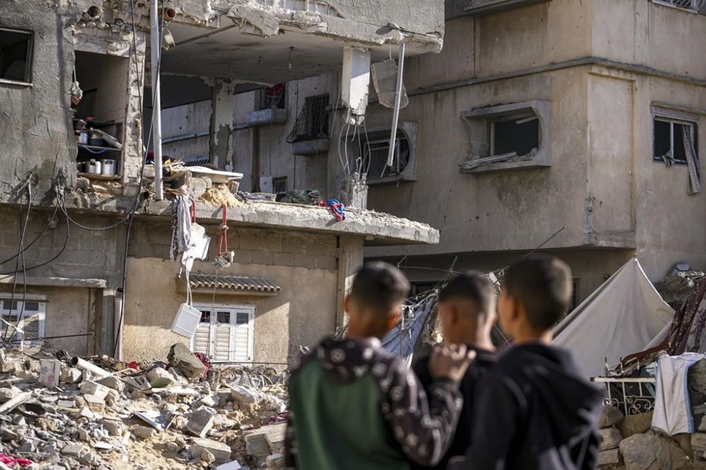 FILE - Palestinians look at a damaged residential building following an overnight Israeli strike in Deir al-Balah, Gaza Strip, Wednesday, Jan. 8, 2025. (AP Photo/Abdel Kareem Hana, File)