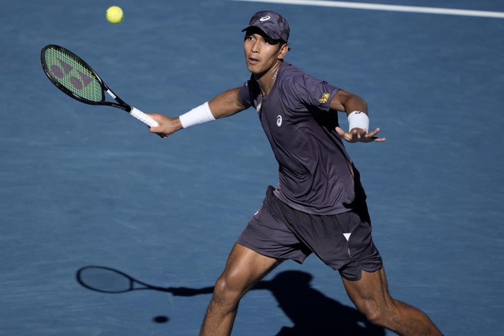 Kasidit Samrej of Thailand plays a forehand return to Daniil Medvedev of Russia during their first round match at the Australian Open tennis championship in Melbourne, Australia, Tuesday, Jan. 14, 2025. (AP Photo/Ng Han Guan)
