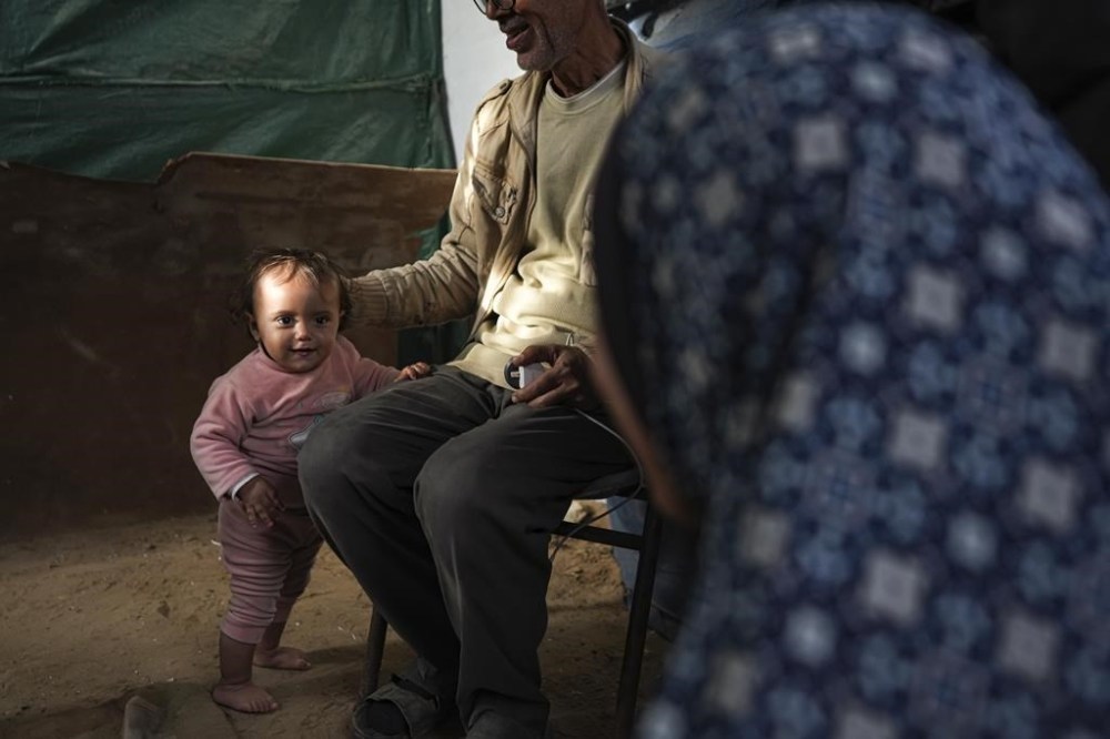 Massa Zaqout, a 15-month-old child, stands inside her family's tent at a camp for displaced Palestinians in Deir al-Balah, central Gaza Strip, Tuesday, Jan. 14, 2025. (AP Photo/Abdel Kareem Hana)
