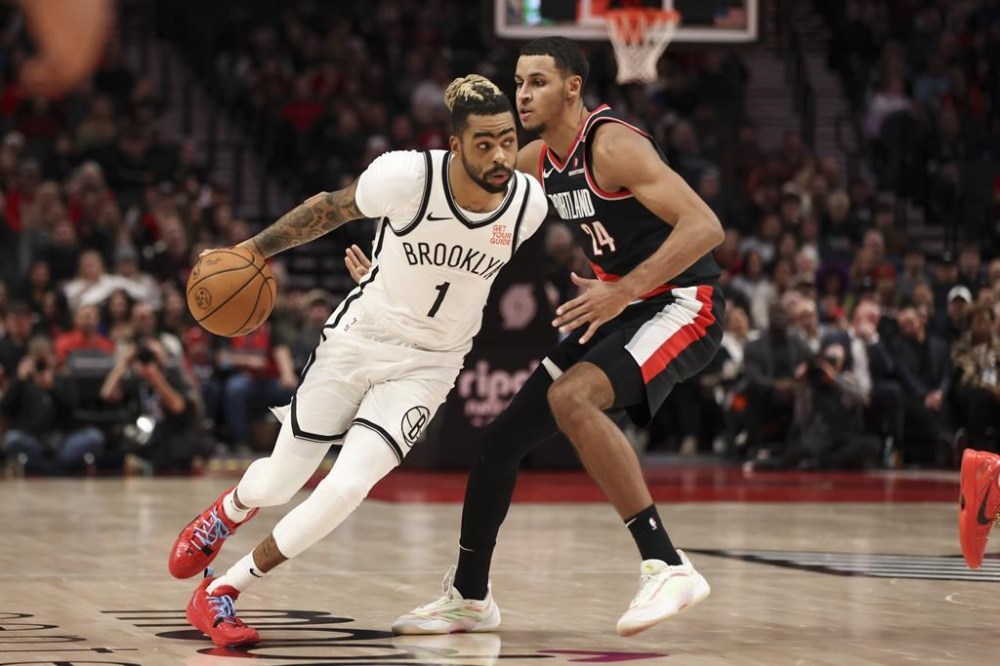 Brooklyn Nets guard D'Angelo Russell (1) brings the ball up court as Portland Trail Blazers forward Kris Murray (24) defends during the first half of an NBA basketball game, Tuesday, Jan. 14, 2025, in Portland, Ore. (AP Photo/Amanda Loman)