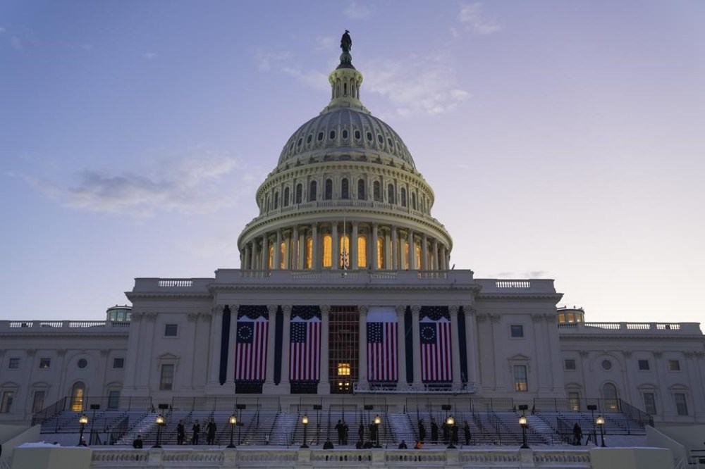 The sun rises as a rehearsal begins for President-elect Donald Trump's upcoming inauguration on the West Front of the U.S. Capitol, Sunday, Jan. 12, 2025, in Washington. (AP Photo/Jon Elswick)