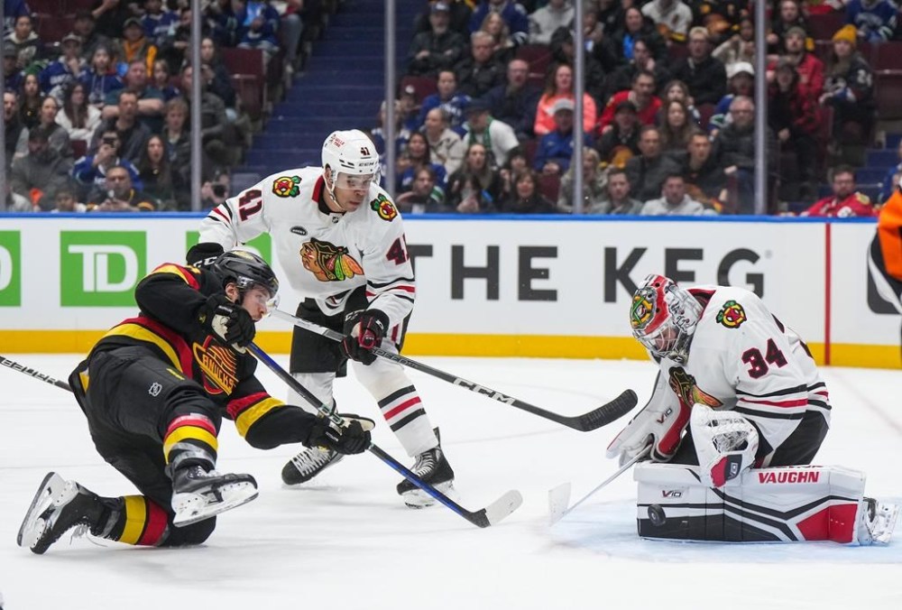 Chicago Blackhawks goalie Petr Mrazek (34) stops Vancouver Canucks' Pius Suter, front left, as Chicago's Isaak Phillips (41) watches during the second period of an NHL hockey game in Vancouver, on Monday, January 22, 2024. The Winnipeg Jets have acquired defenceman Phillips from the Chicago Blackhawks in exchange for defenceman Dmitry Kuzmin, the NHL club announced Wednesday.THE CANADIAN PRESS/Darryl Dyck