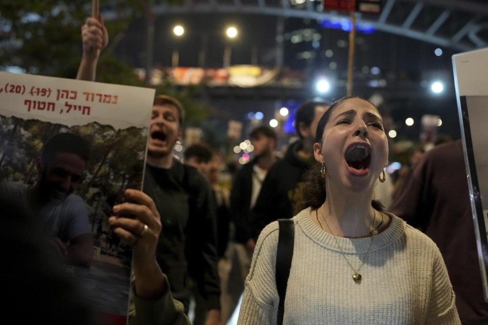 Relatives and friends of people killed and abducted by Hamas and taken into Gaza, react to the ceasefire announcement as they take part in a demonstration in Tel Aviv, Israel, Wednesday, Jan. 15, 2025. (AP Photo/Ohad Zwigenberg)