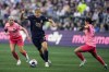 Seattle Reign midfielder Quinn, center, moves the ball against North Carolina Courage midfielder Denise O'Sullivan (10) and midfielder Manaka Matsukubo (34) during the first half of an NWSL soccer match, Sunday, Aug. 25, 2024, in Seattle. Vancouver Rise FC signed Canadian midfielder Quinn to the roster ahead of the inaugural Northern Super League season. (AP Photo/Lindsey Wasson)