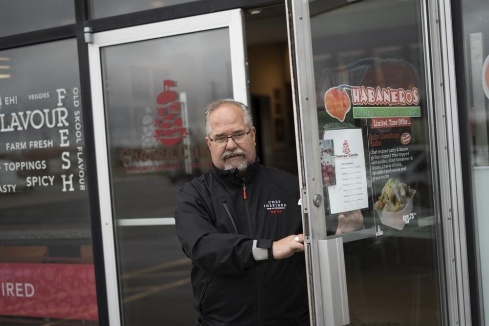 Bill Pratt, a veteran chef and CEO of Chef Inspired Group of Restaurants, walks out a shared restaurant space of Cheese Curds Gourmet Burgers + Poutinerie and Habaneros Modern Taco Bar in Dartmouth, N.S. on May 17, 2023. THE CANADIAN PRESS/Darren Calabrese