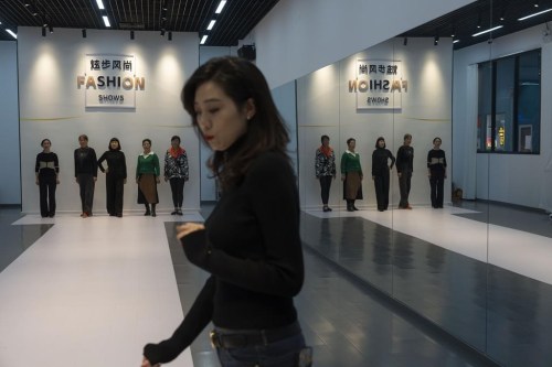 FILE - Women line up as they learn how to walk on the catwalk from an instructor during a modeling class at the University for the Elderly in Beijing, Oct. 23, 2024. (AP Photo/Ng Han Guan, File)