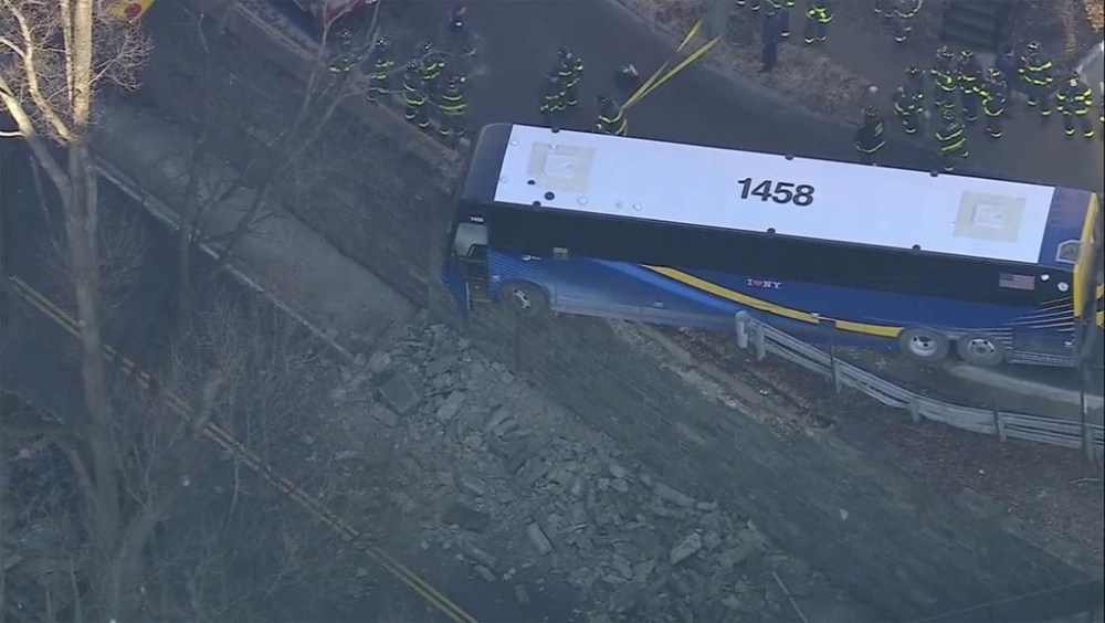 A Manhattan-bound bus hangs over a stone wall near a near a bridge in the Bronx borough of New York on Friday, Jan. 17, 2025. (WABC-TV via AP)