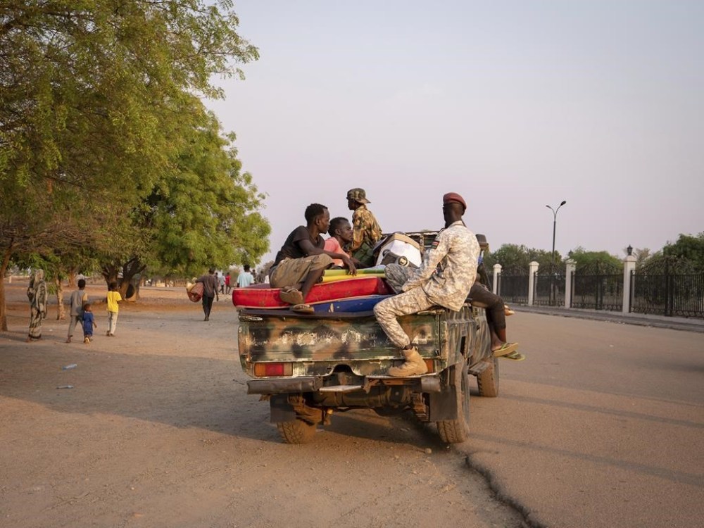 Sudanese nationals carrying their belongings arrive at the South Sudan People's Defense Forces (SSPDF) headquarters after a night of violence in Juba, South Sudan, on Friday, Jan. 17, 2025. (AP Photo/Florence Miettaux)