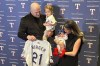 Texas Rangers first baseman Jake Burger poses at the team's awards dinner Friday, Jan. 17, 2025, in Arlington, Texas, with wife Ashyln, son Brooks and daughter Penelope while holding the No. 21 jersey that has special significance after his daughter was born with Down syndrome. (AP Photo/Stephen Hawkins)