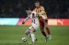 PSG's Fabian Ruiz, left, and Lens' Przemyslaw Frankowski fight for the ball during the French League One soccer match between Lens and Paris Saint-Germain, at the Bollaert-Delelis stadium in Lens, France, Saturday, Jan. 18, 2025. (AP Photo/Thibault Camus)
