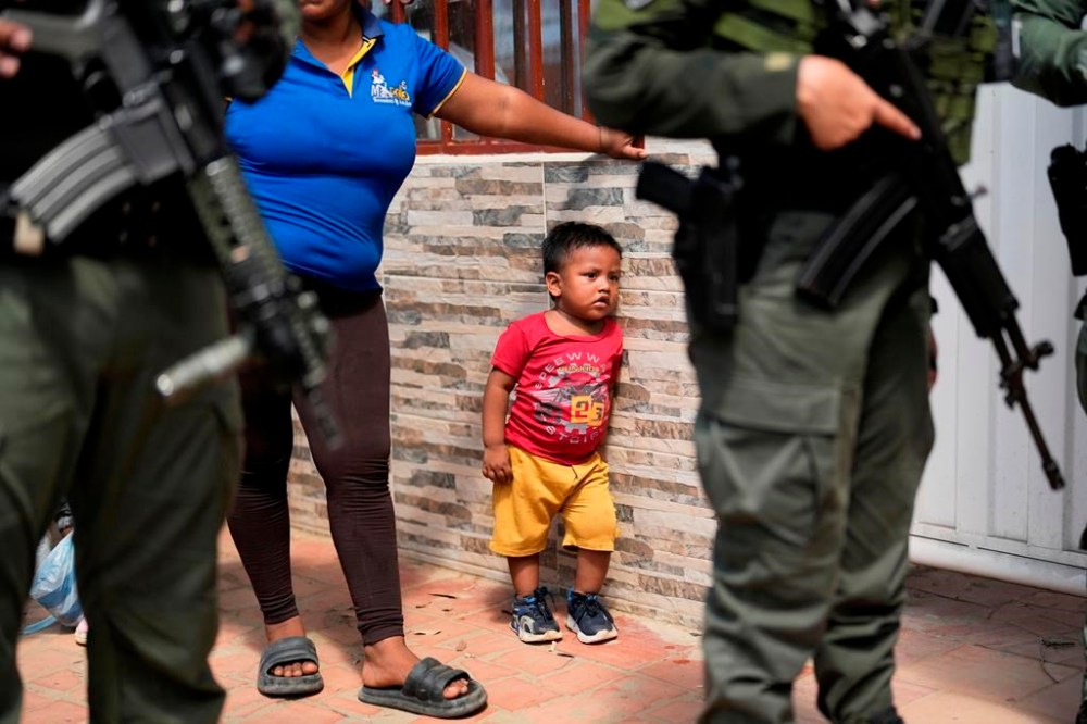 Police guard a school serving as a shelter for people displaced by violence in the Catatumbo region, where rebels of the National Liberation Army (ELN) have been clashing with former members of the Revolutionary Armed Forces of Colombia (FARC), in Tibu, Colombia, Monday, Jan. 20, 2025. (AP Photo/Fernando Vergara)