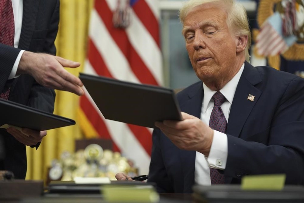 President Donald Trump signs executive orders in the Oval Office of the White House, Monday, Jan. 20, 2025, in Washington. (AP Photo/Evan Vucci)