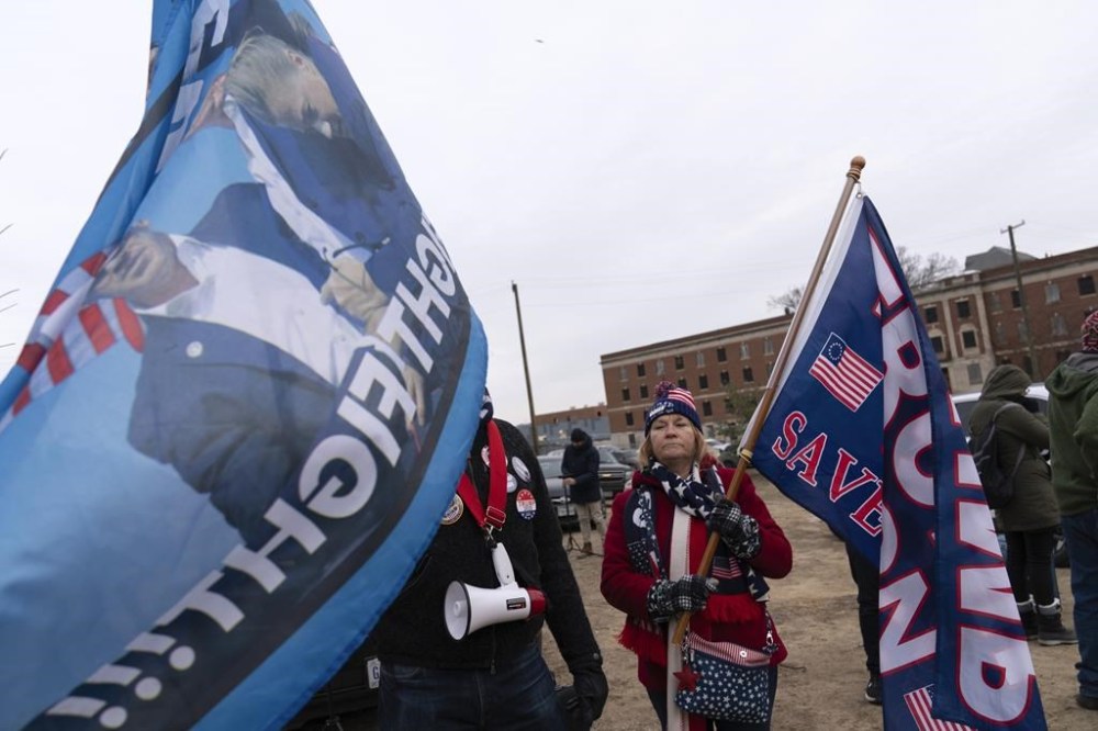 Supporters of President Donald Trump stand with their flags in support of people convicted for their part in the Jan. 6 riot at the U.S. Capitol at the DC Central Detention Facility in Washington, Tuesday, Jan. 21, 2025. (AP Photo/Jose Luis Magana)