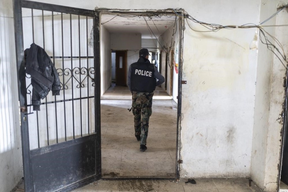 A member of the new Syrian security regime walks in ammunition that belonged to the Assad regime, in Nawa, near Daraa, Syria, Jan. 4, 2025. (AP Photo/Mosa'ab Elshamy)