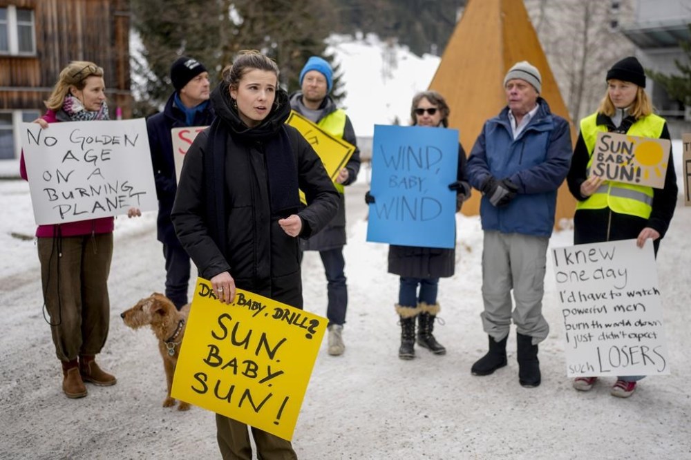 Climate activist Luisa Neubauer, front, takes part in a small protest at the Annual Meeting of World Economic Forum in Davos, Switzerland, Wednesday, Jan.22, 2025. (AP Photo/Markus Schreiber)