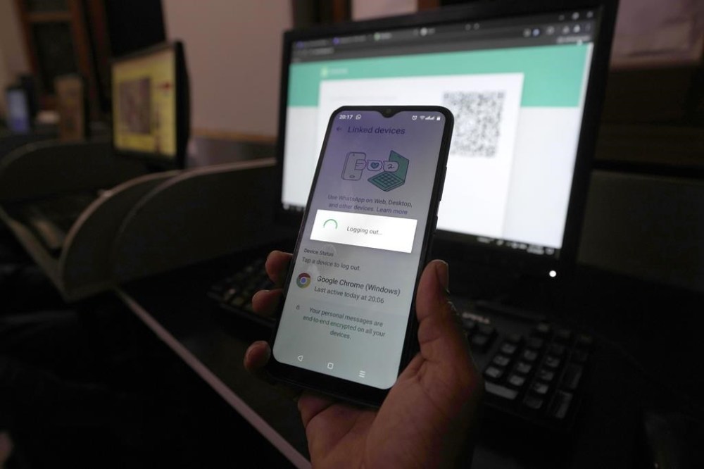FILE -A Pakistani waits to connect his mobile WhatsApp with a desktop as internet runs slow past several days, in Karachi, Pakistan, Aug. 19, 2024. (AP Photo/Fareed Khan, File)