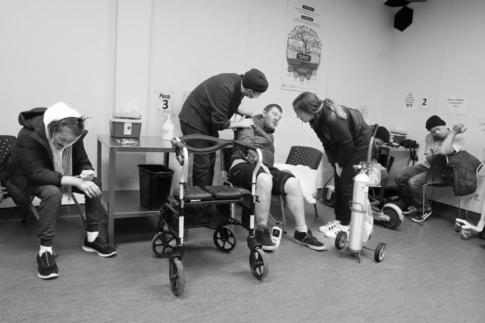 Julianne Lavoie, a nurse practitioner, and community health worker Evan Moore attend to a service user after he was treated for signs of an overdose in the consumption room at the Moss Park Consumption and Treatment Service, in Toronto on Thursday, Dec. 5, 2024. THE CANADIAN PRESS/Chris Young