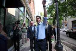 Trudeau waves to supporters as he walks down McDermot Avenue with Free Press editor Paul Samyn before an event at the Free Press News Cafe in 2016. (Ruth Bonneville / Free Press files)