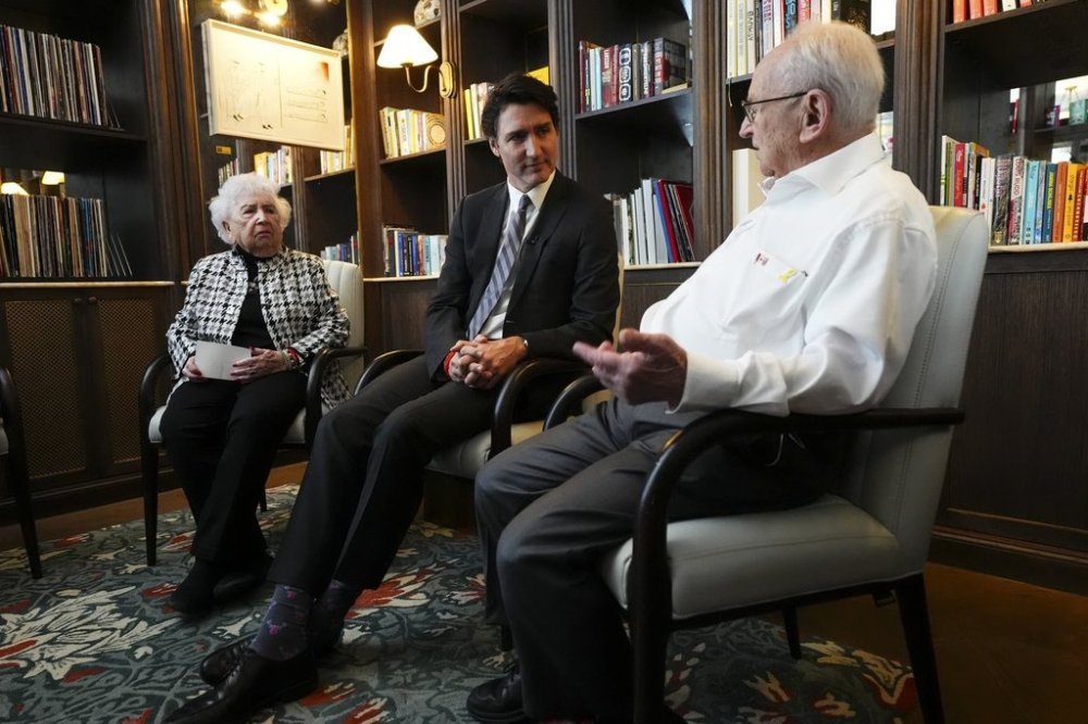 Canadian Holocaust survivors Miriam Ziegler, left, and Howard Chandler, right, speak with Prime Minister Justin Trudeau in Krakow, Poland on Monday, Jan. 27, 2025. They are accompanying the prime minister to an event marking the 80th anniversary of the liberation of the Auschwitz Birkenau Nazi concentration and extermination camp. THE CANADIAN PRESS/Sean Kilpatrick