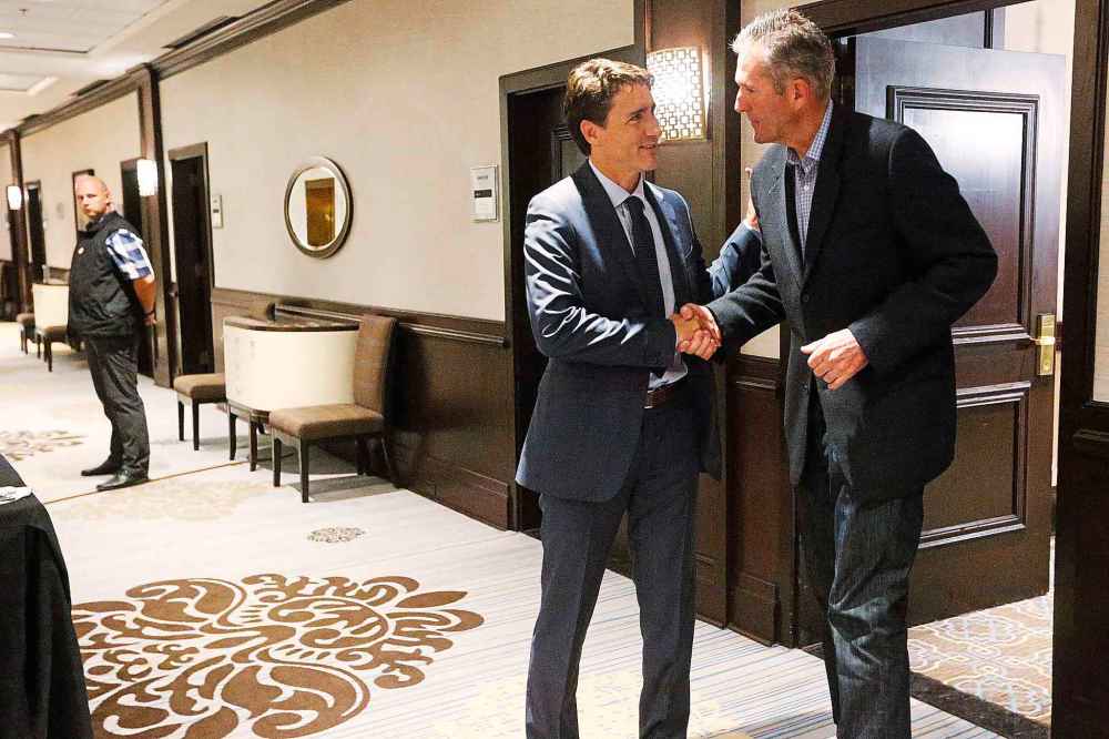 A security officer looks on as Trudeau and then-Manitoba Premier Brian Pallister say their goodbyes after meeting in Winnipeg in 2017. (John Woods / The Canadian Press files)