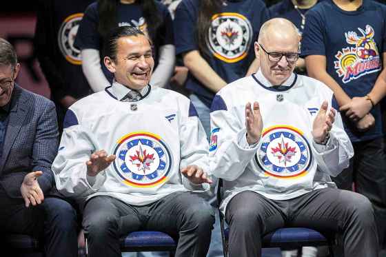 Manitoba Premier Wab Kinew and Winnipeg Mayor Scott Gillingham model the new WASAC Jets jerseys. (Mikaela MacKenzie / Free Press)