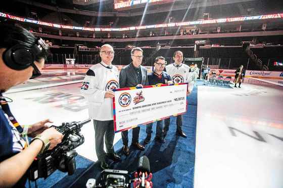 Mayor Scott Gillingham (from left), Jets co-owner Mark Chipman, WASAC executive director Trevor LaForte and Premier Wab Kinew pose with the cheque from True North Sports + Entertainment, representing funds the initiative has raised over the past year. (Mikaela MacKenzie / Free Press)