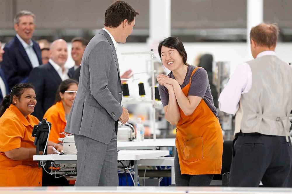 Canada Goose employee Seolhee Lee greets Trudeau during a brief tour of a new 700-employee Canada Goose manufacturing facility in Winnipeg in 2018. (John Woods / The Canadian Press files)
