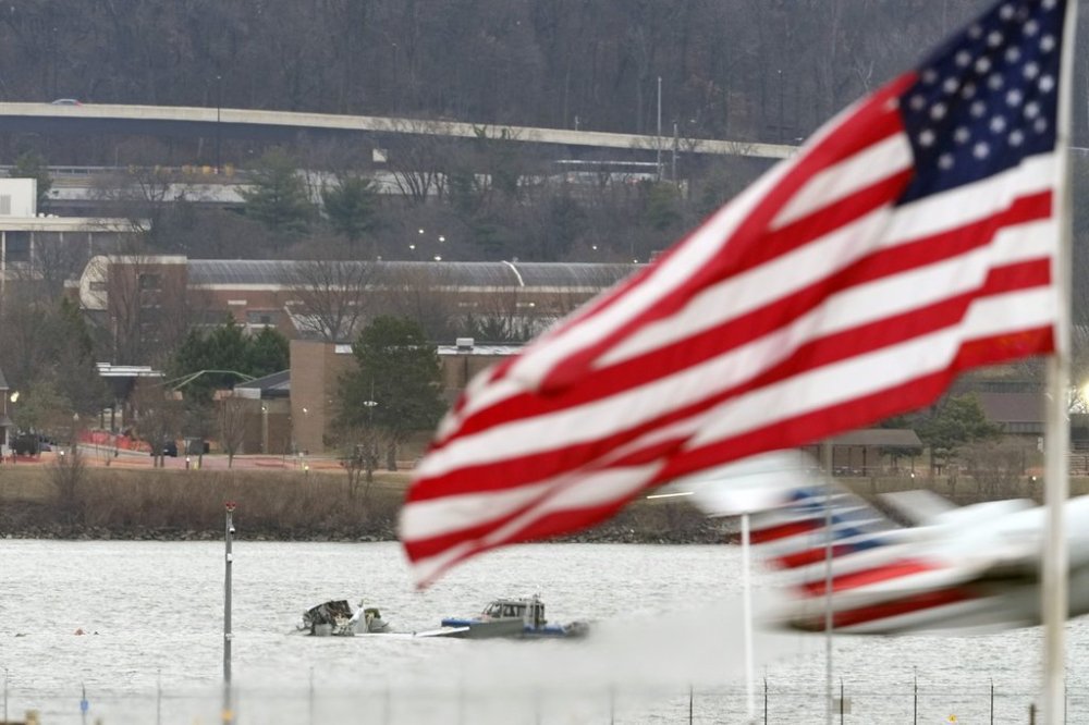 Search efforts are seen around a wreckage site of a deadly midair collision between an American Airlines jet and an Army helicopter, in the Potomac River near Ronald Reagan Washington National Airport, Friday, Jan. 31, 2025, in Arlington, Va., as an American Airlines jet lifts off from the airport. (AP Photo/Alex Brandon)