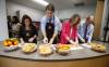 Educational assistant Kim Jemielity, Prime Minister Justin Trudeau, Jenna Sudds, Minister of Families, Children and Social Development, and MP Kevin Lamoureux prepare food for students at a school food program at Elwick Community School in Winnipeg, Friday, May 17, 2024. The federal Liberals and Manitoba’s provincial NDP government have signed a deal to expand school food programs in the province. (John Woods / The Canadian Press files)