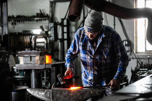 MIKAELA MACKENZIE / FREE PRESS
                                Lynndon Novak works on the anvil in his backyard shop.