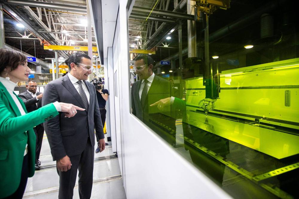 MIKAELA MACKENZIE / FREE PRESS
Premier Wab Kinew takes a look at a computer-controlled laser that is cutting exhaust flanges for jet engines, after a funding announcement Thursday at Magellan Aerospace in Winnipeg.