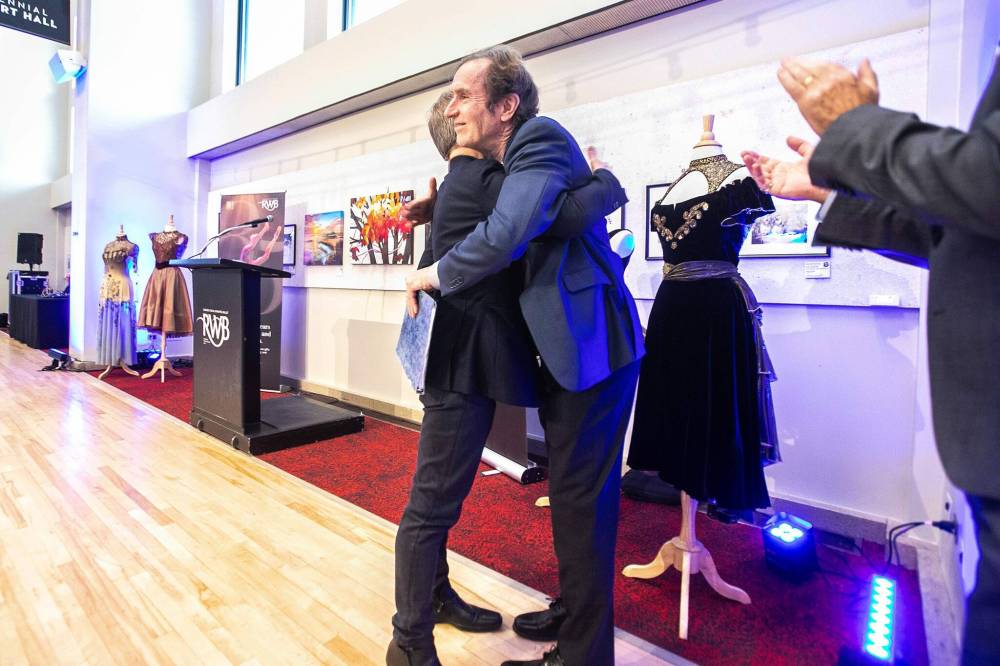 The Royal Winnipeg Ballet’s new artistic director, Christopher Stowell, hugs outgoing artistic director André Lewis after the change was announced at the Centennial Concert Hall on Friday. (Mikaela MacKenzie / Free Press)