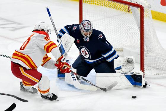 Winnipeg Jets’ goaltender Eric Comrie makes one of his 20 saves against Calgary Flames’ Blake Coleman during NHL action in Winnipeg on Sunday. (Fred Greenslade / The Canadian Press files)