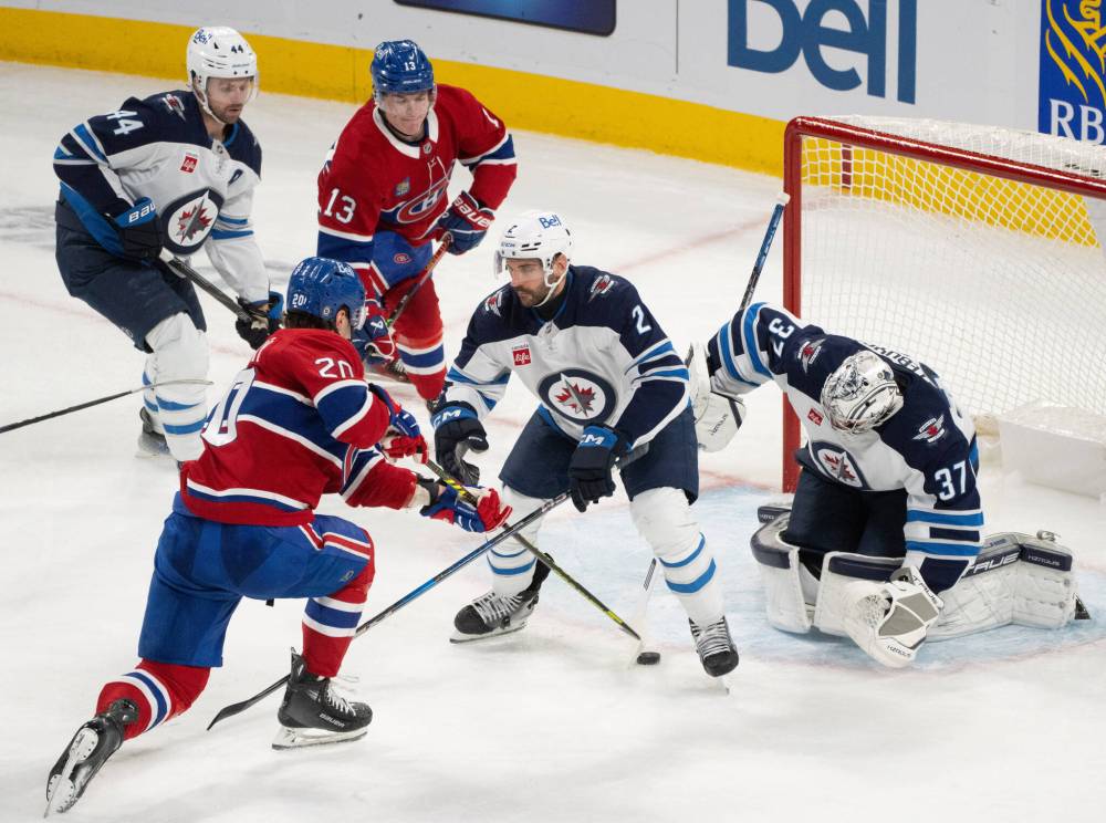 Christinne Muschi / THE CANADIAN PRESS
Jets goaltender Connor Hellebuyck stops the Canadiens’ Juraj Slafkovsky as Dylan DeMelo defends during the second period.