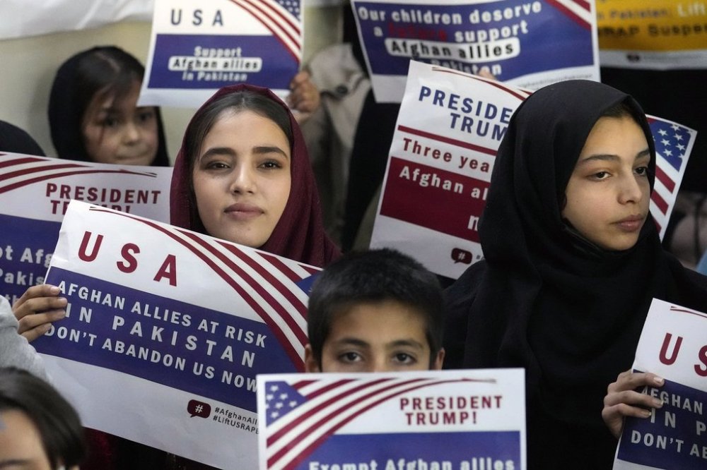 FILE - Afghan refugees hold placards during a meeting to discuss their situation after President Donald Trump paused U.S. refugee programs, in Islamabad, Pakistan, Jan. 24, 2025. (AP Photo/Anjum Naveed, File)