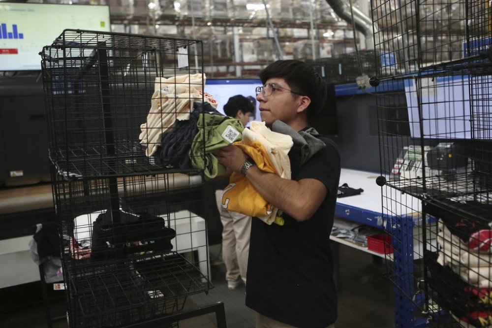 An employee works at a textile factory that produces T-shirts, in Ciudad Juarez, Mexico, Tuesday, Feb. 4, 2025. (AP Photo/Christian Chavez)