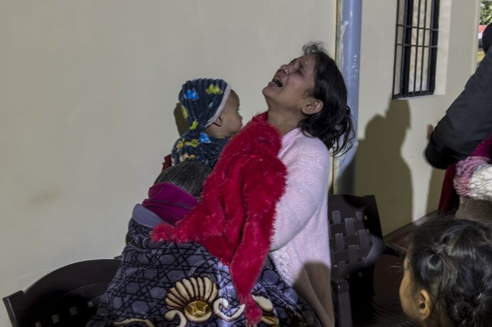 Wife of Amit, a man from Haryana who died in the early morning stampede during the Maha Kumbh festival, weeps holding her child outside a mortuary in Prayagraj, India, Wednesday, Jan. 29, 2025. (AP Photo/Rajesh Kumar Singh)
