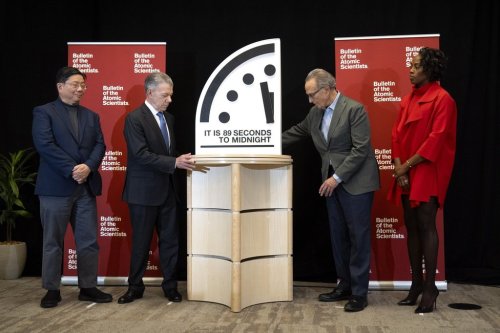 Former Colombian President Juan Manuel Santos, second from left, and Bulletin of the Atomic Scientists member Robert Socolow, second from right, reveal the Doomsday Clock, set at 89 seconds to midnight, as fellow members Herbert Lin, left, and Suzet McKinney, right, watch during a news conference at the United States Institute of Peace, Tuesday, Jan. 28, 2025, in Washington. (AP Photo/Mark Schiefelbein)