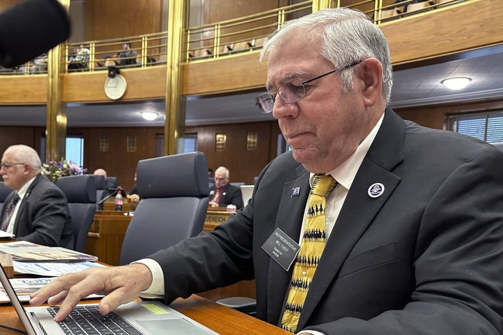 North Dakota Republican state Rep. Bill Tveit works at his desk on Wednesday, Jan. 22, 2025, in the House of Representatives at the state Capitol in Bismarck, N.D. (AP Photo/Jack Dura)
