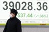 A person walks in front of an electronic stock board showing Japan's Nikkei index at a securities firm Tuesday, Jan. 28, 2025, in Tokyo. (AP Photo/Eugene Hoshiko)