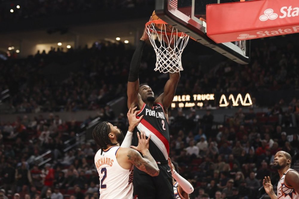 Portland Trail Blazers center Deandre Ayton (2) dunks over Phoenix Suns center Nick Richards (2) during the first half of an NBA basketball game Saturday, Feb. 1, 2025, in Portland, Ore. (AP Photo/Amanda Loman)
