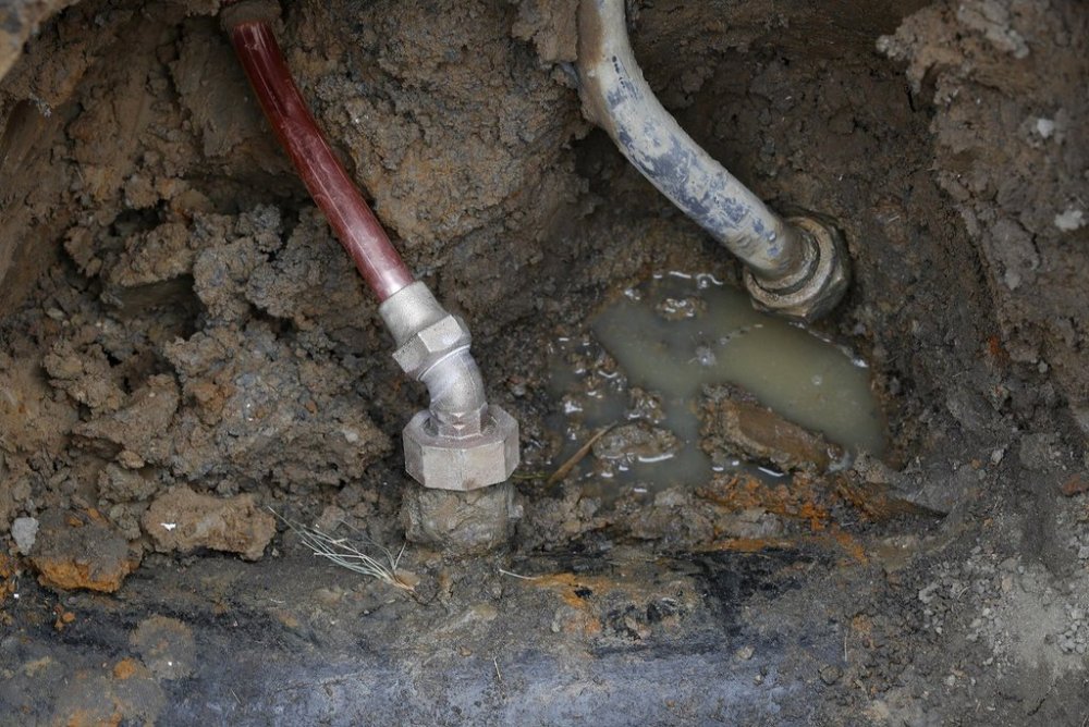 FILE - A copper water supply line, left, is shown connected to a water main after being installed for a lead pipe, right, July 20, 2018, in Flint, Mich. (AP Photo/Paul Sancya, File)