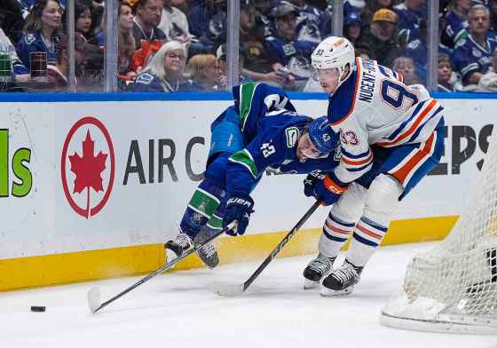 Edmonton Oilers' Ryan Nugent-Hopkins, right, checks Vancouver Canucks' Quinn Hughes during a playoff game last season. Hughes is set to go head-to-head with Morrissey tonight. (Darryl Dyck/The Canadian Press files)